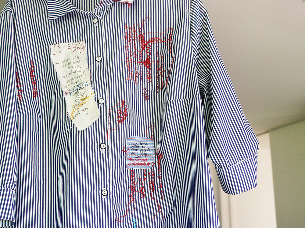 embroidery project by Tatiana Zakharova-Goodman; a shirt which includes embroidered notes from 2026 CSSE (Canadian Society for the Study of Education) Conference; detail featuring a list handwritten on fabric by Sylvia Kind